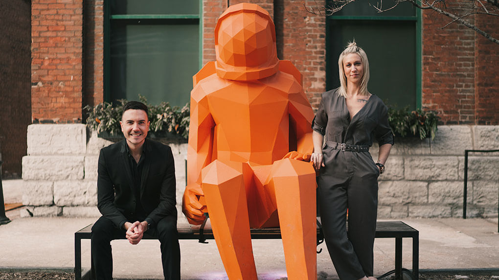 Mitchell and Lauren standing next to an astronaut statue