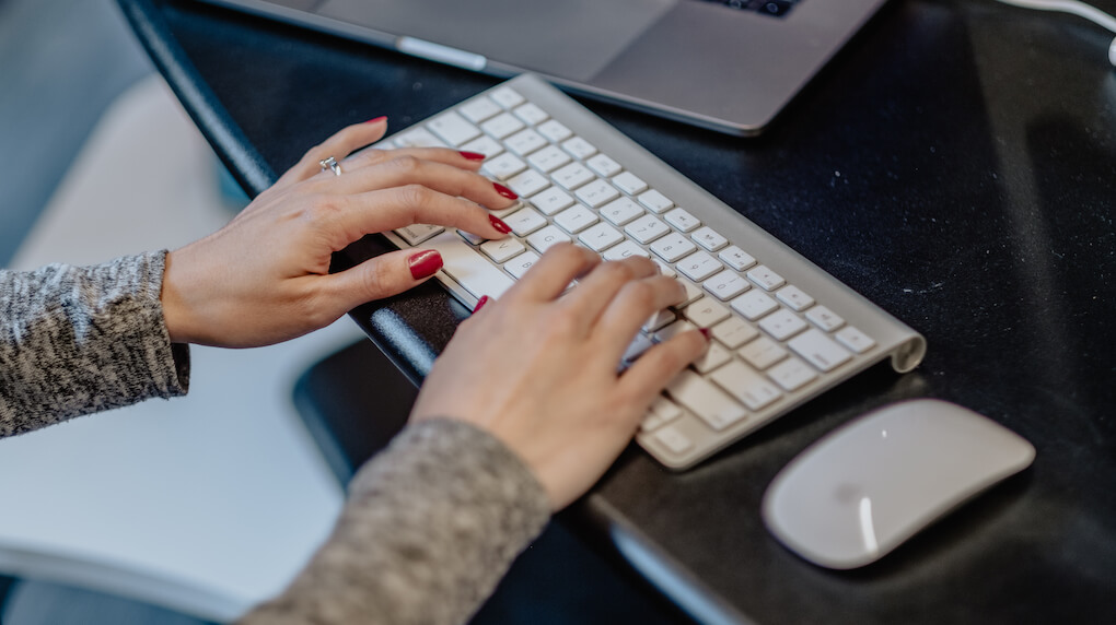 both hands typing on keyboard