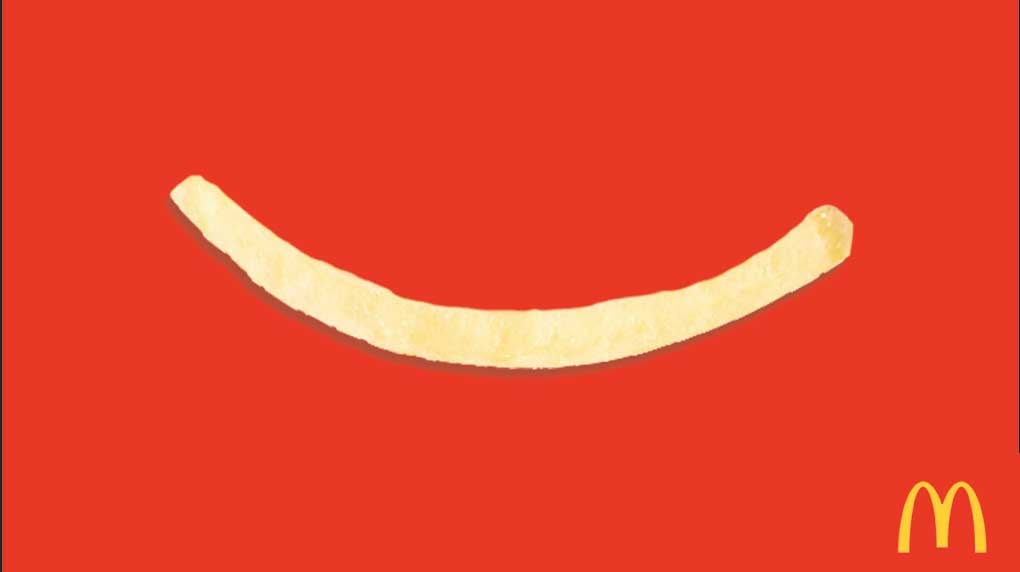 a french fry on a red background with a small mcdonalds logo in the corner