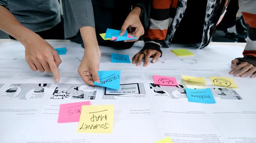 people placing down sticky notes