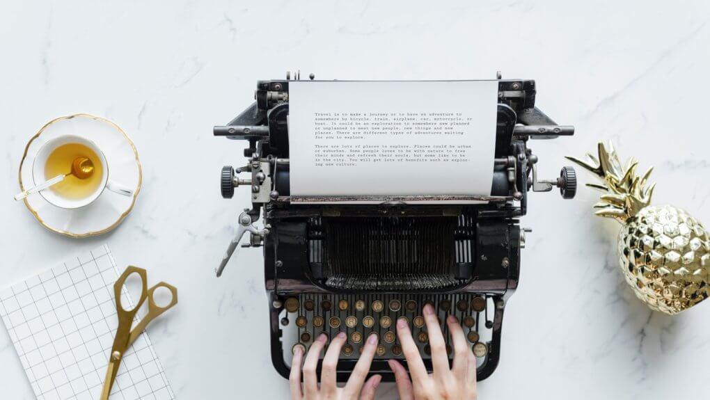 person typing on typewriter