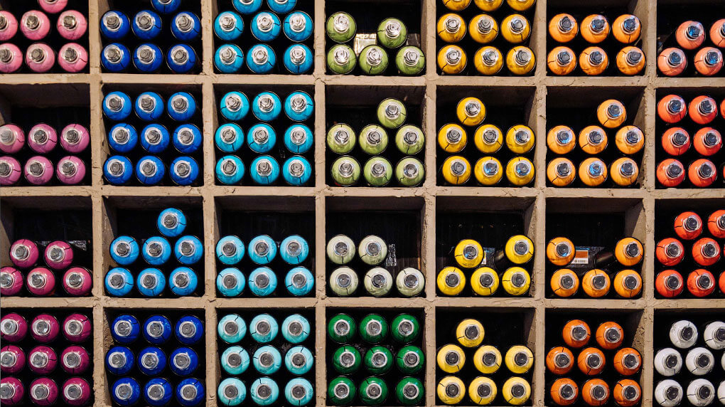 tubes of paint separated by color on shelves