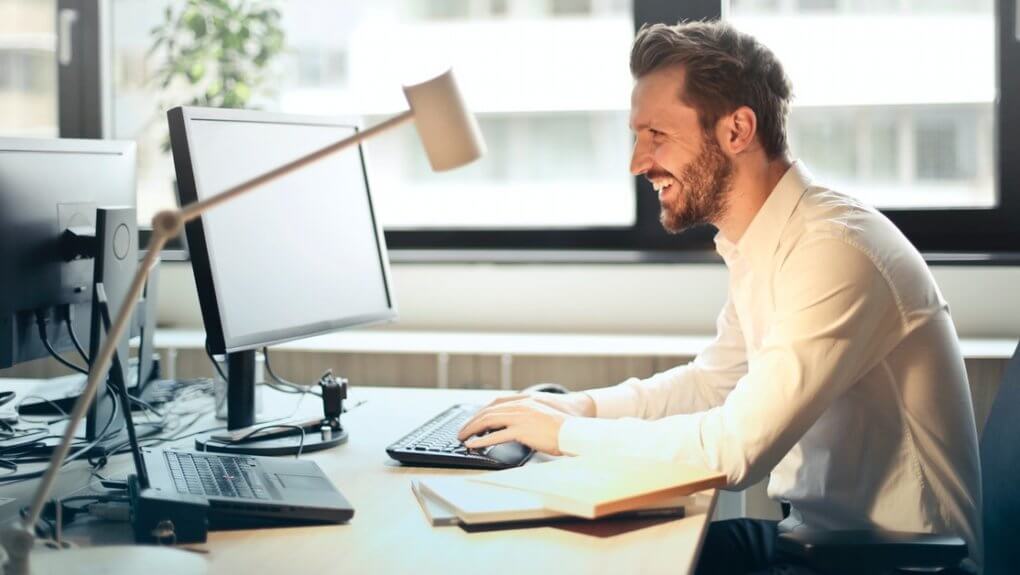 smiling man working on the laptop