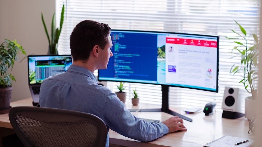 man with two screens working at home